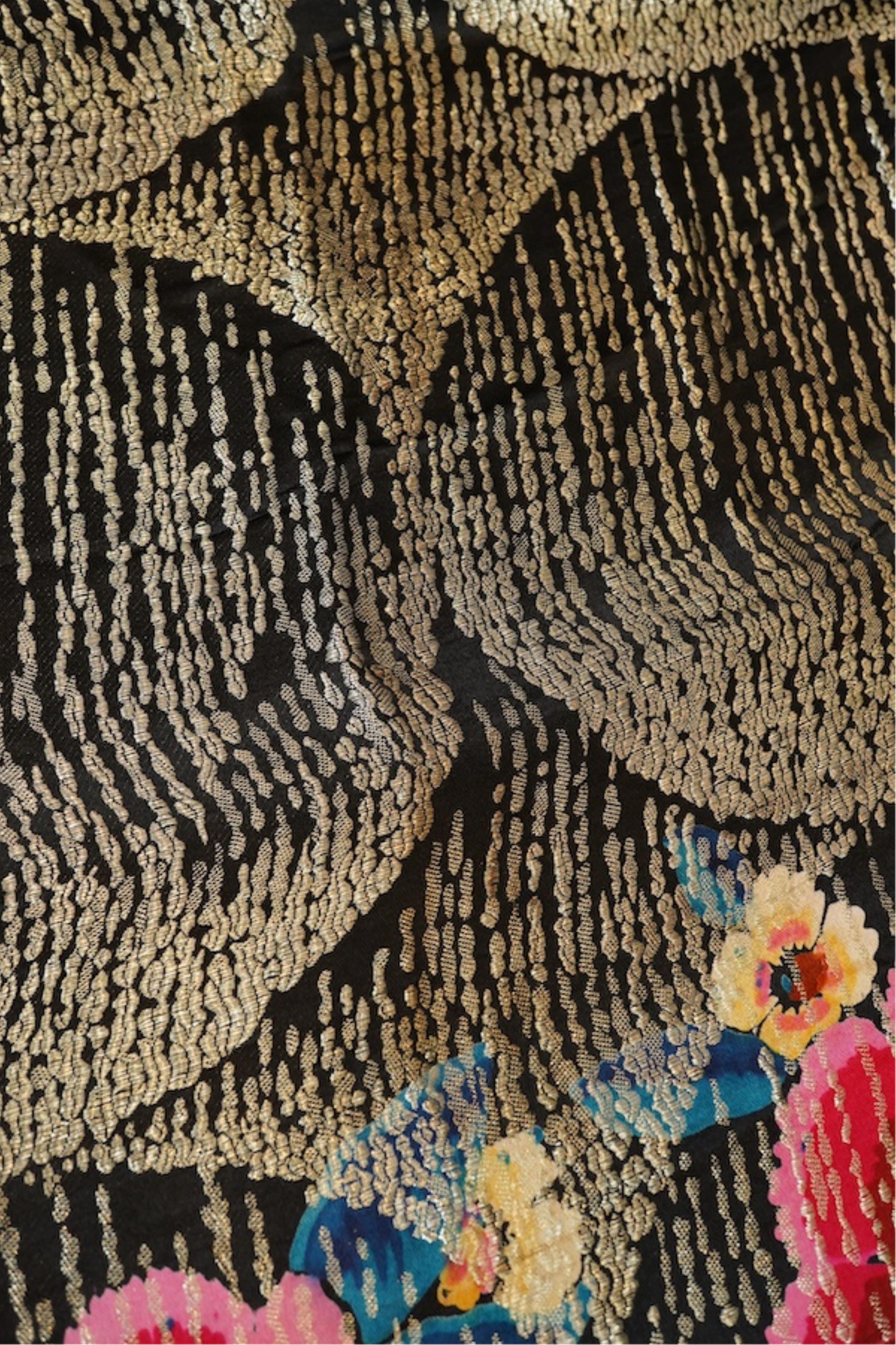 A 1930's ‘jazz age’ black and coloured silk lame evening shawl. Woven with giant pink and red roses and silver thread stripes, edged with long silk fringing. 118cm x 123cm. Condition - colours and silk strong. Fringing g